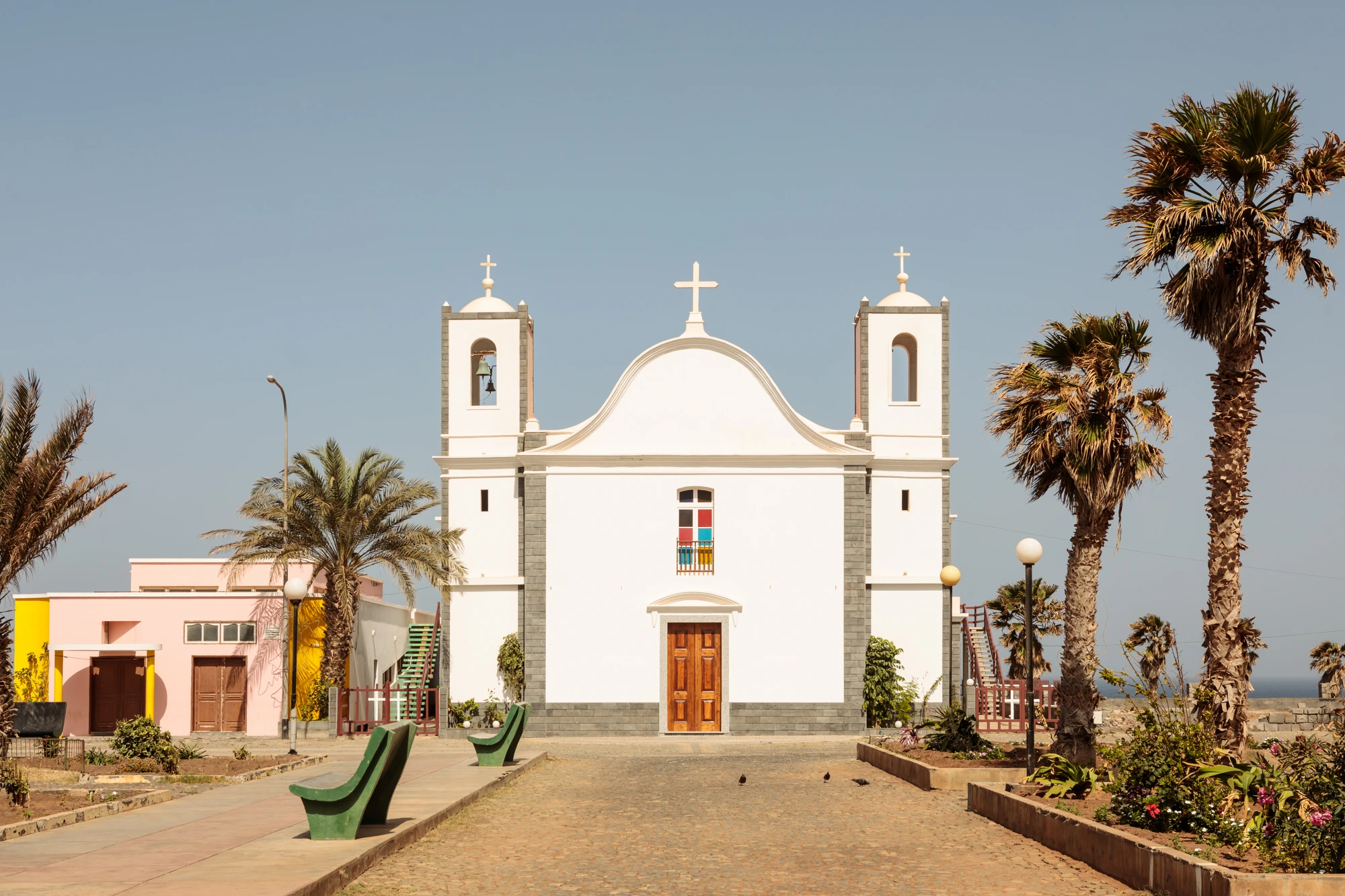 Real Estate Cabo Verde, white colonial church of São Vicente with palm trees