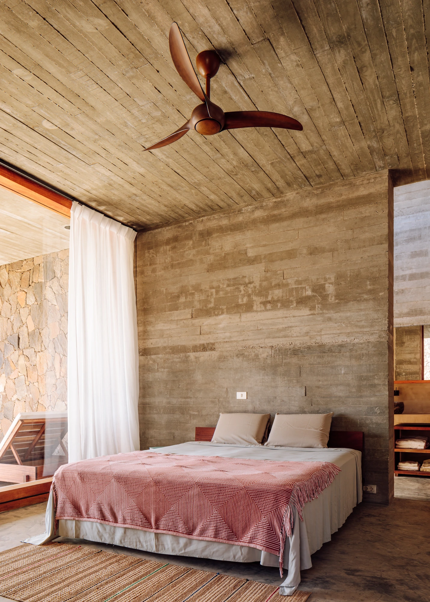 Real Estate Cabo Verde, master bedroom with ceiling fan and stone accent wall on São Vicente